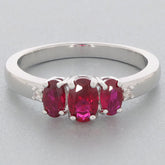 Red Ruby Sterling Silver Ring featuring three oval gemstones with accent stones, perfect for an elegant touch.